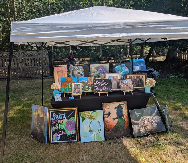 Art Day Dream canopy booth with paintings at an outdoor market
